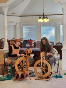 Two spinners at spinning wheels