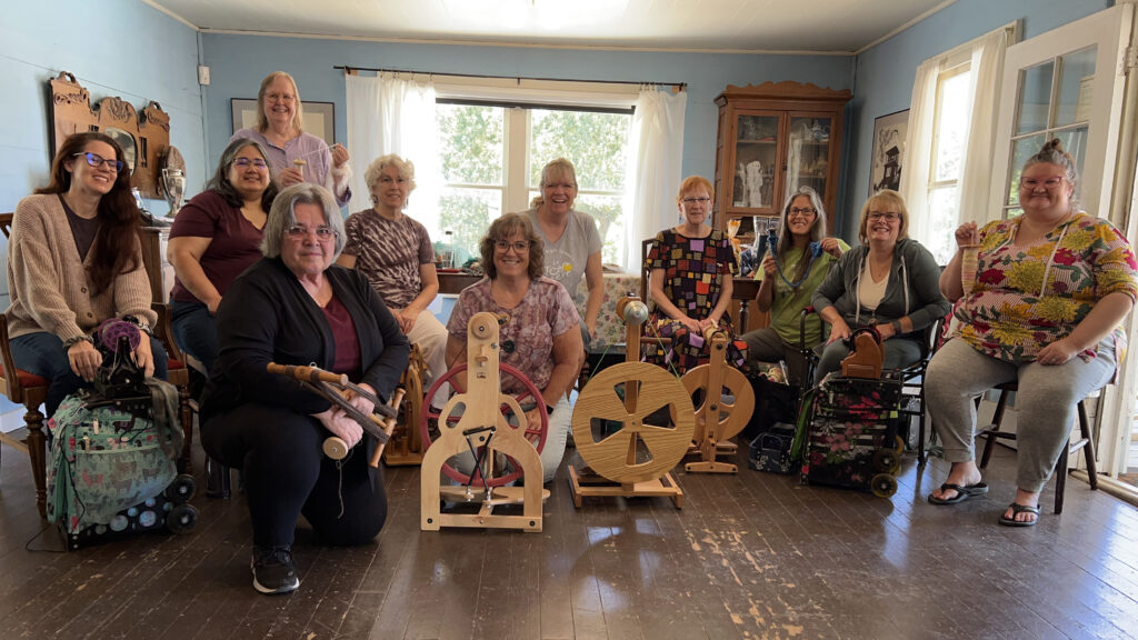 Ten guild members with spinning wheels